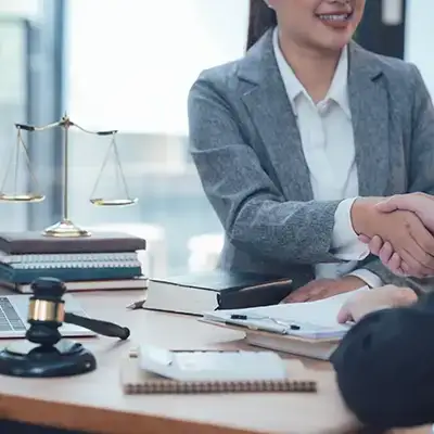A female laywer shaking hands with a client.