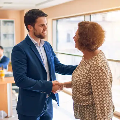 A laywer standing and shaking hands with a client.